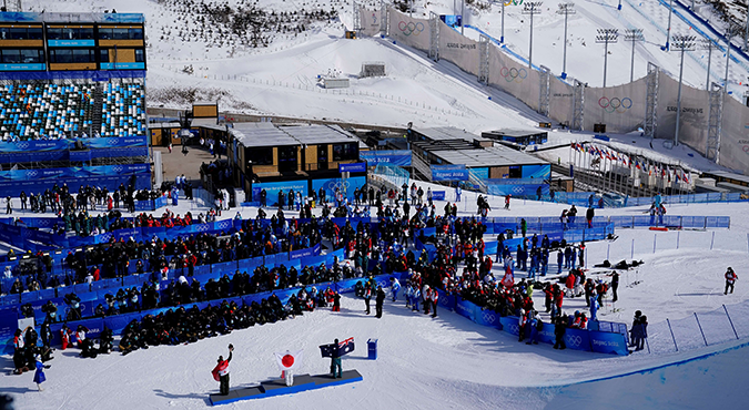 China zet heaters langs kunstsneeuwpistes om toeschouwers warm te houden