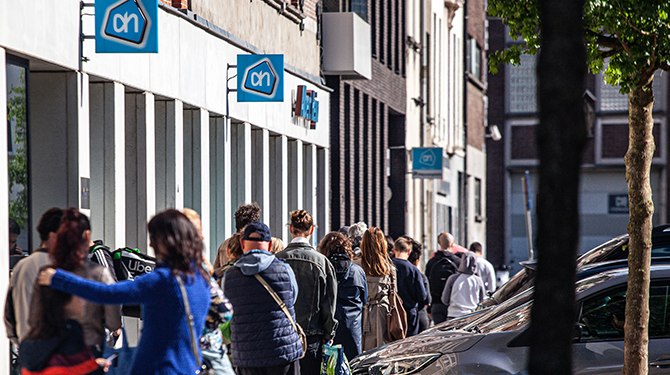 Lange rijen voor supermarkten om nog een keer zonder mondkapje op de groenteafdeling te kunnen niezen