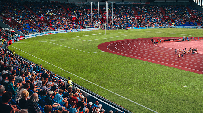 Sfeerloos atletiekstadion heeft voetbalveld om sintelbaan heen