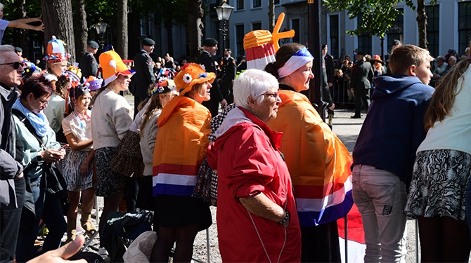 ​Man met oranje kaashoed op zijn hoofd die al sinds 05:00 uur langs de route staat geeft Dick Schoof een 8