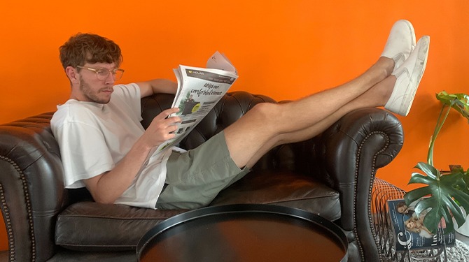 Abonnee opent krant om meer te leren over zomervakanties van columnisten
