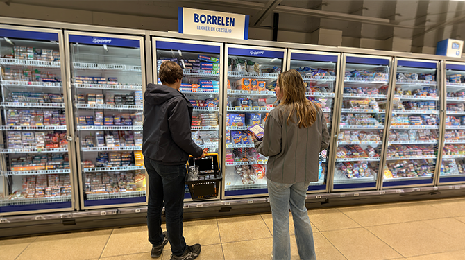 Lisanne kijkt aandachtig naar de stoommaaltijden totdat persoon weggaat die voor de diepvriespizza’s staat