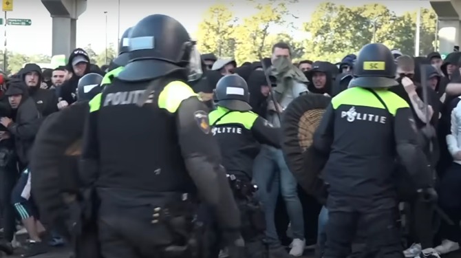 Grote groep mannen met hoodies en bivakmutsen eist transparantie