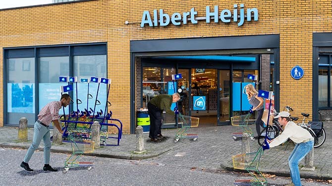 Albert Heijn vervangt alle winkelwagens door kleine met vlaggetjes: ‘Niemand kan meer een volle winkelwagen betalen’