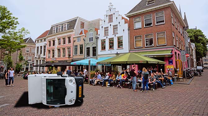 Picnic-busje omgewaaid door vrouw met waaier op terras