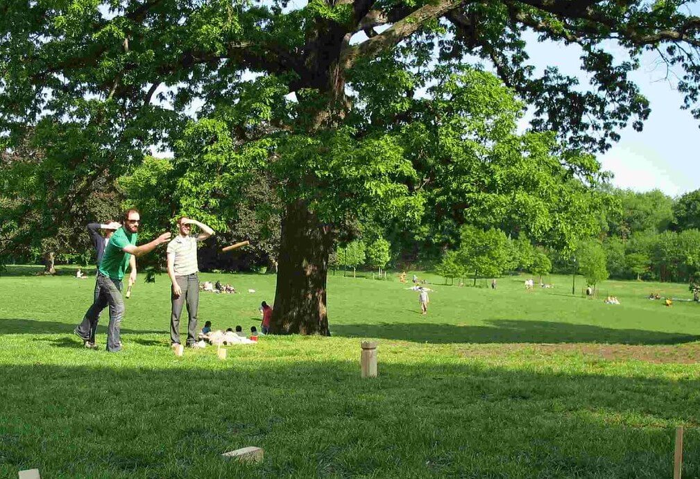 Groepje dat Kubb speelt geïntimideerd door groepje dat Spikeball speelt